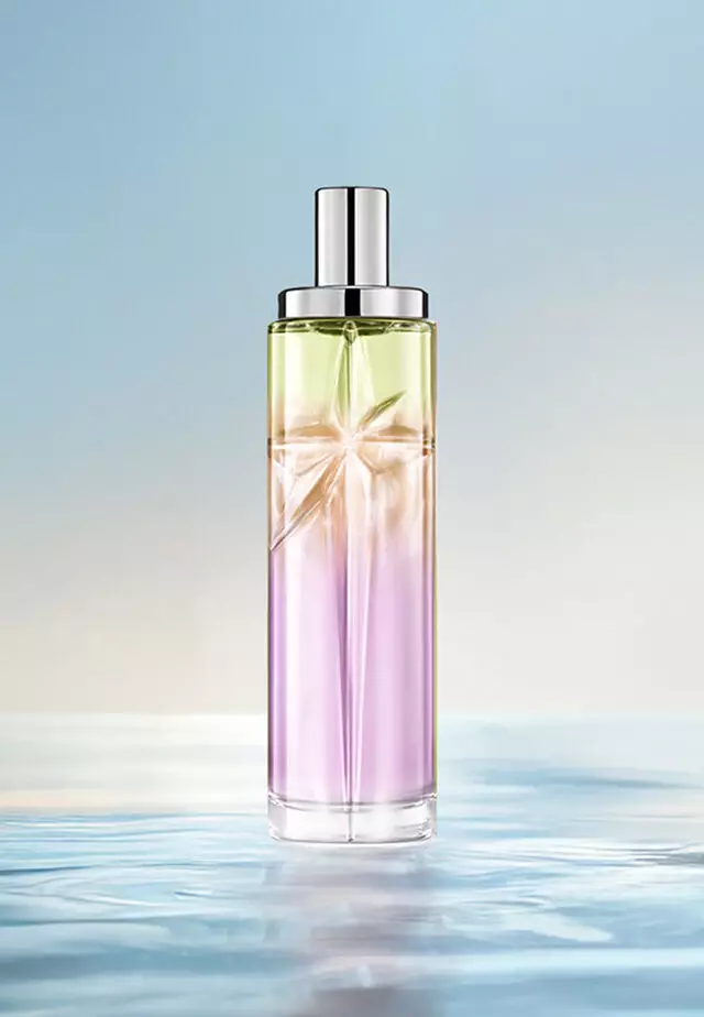 Sweet Kiss Starlicious layering recipe: tall bottle with lavender, amber and light green gradient on water against a soft blue background. Bright, fruity scent with a hint of gourmand; 3 sprays Berry Licorice, 2 Pineapple Musk, 1 Pistachio Praline.