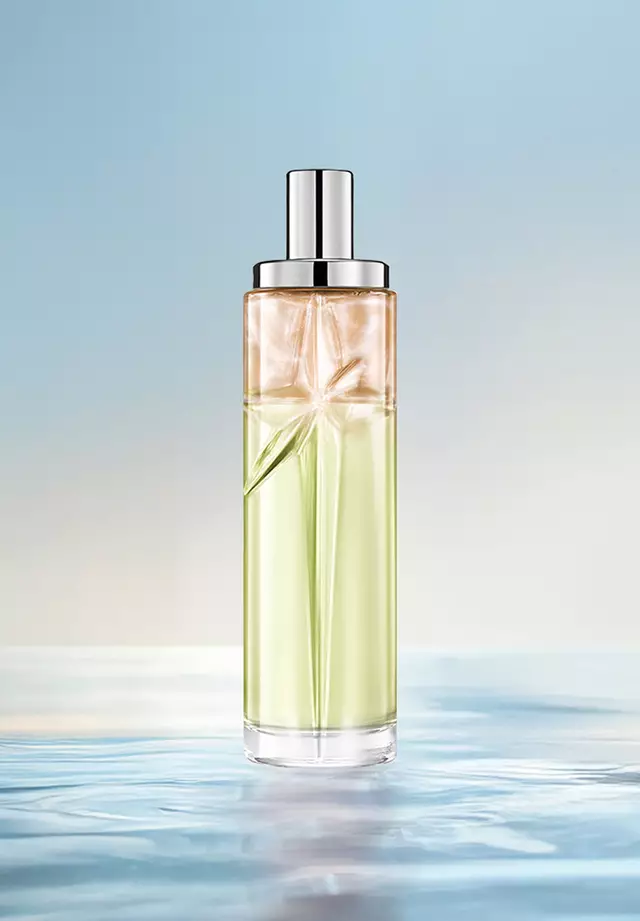 Creamy Delight Starlicious layering recipe: tall bottle with green and amber gradient on water against a soft blue background. Warm, nutty, creamy, slightly sweet scent; 2 sprays Pistachio Praline, 1 Pineapple Musk.