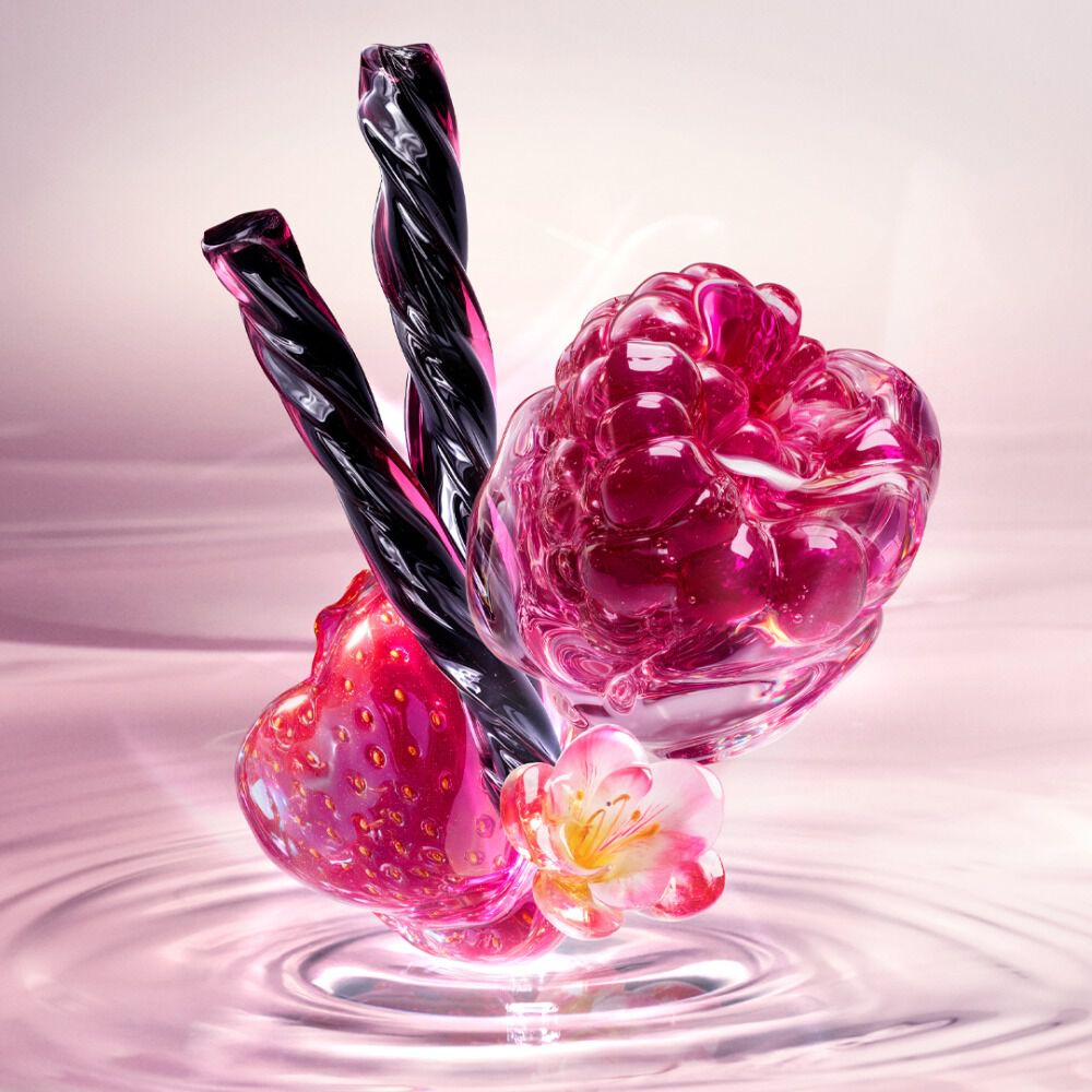 Starlicious Berry Licorice still life: slender pink glass bottle with strawberry, raspberry, pink flower and black licorice sticks on a soft pink rippling water background.