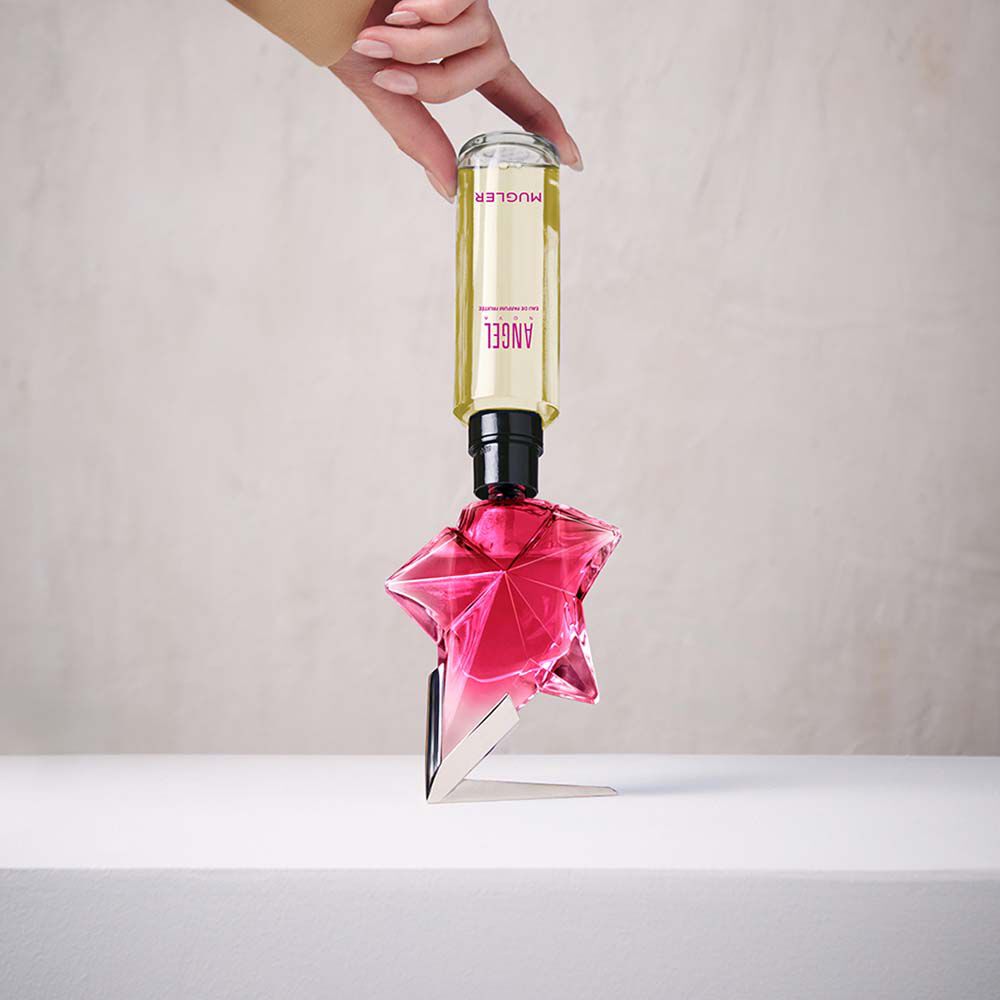 Refilling a pink Angel Nova star perfume bottle with a yellow refill bottle held upside down​