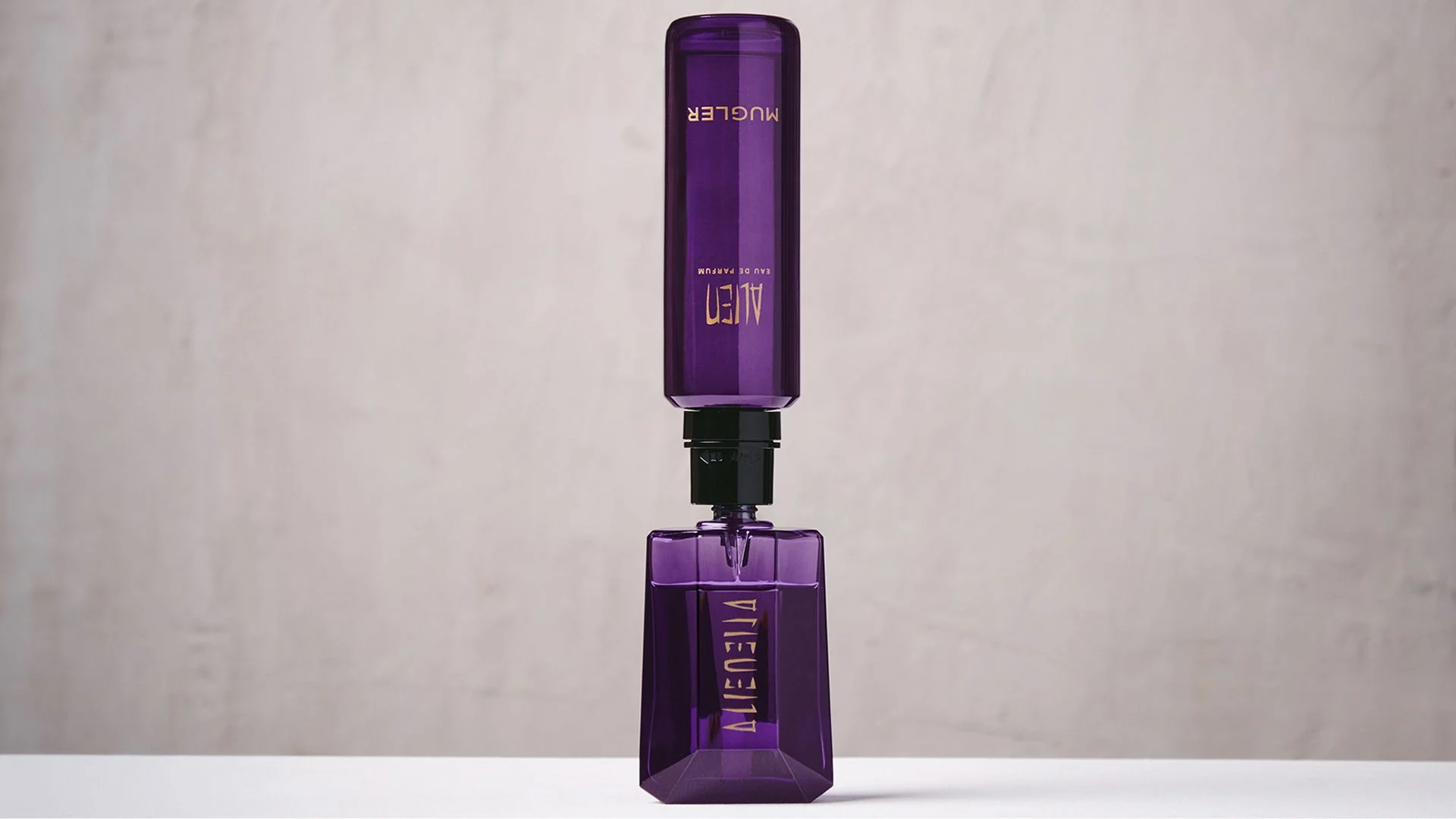 Purple Mugler Alien refill bottle connected upside down to matching perfume bottle