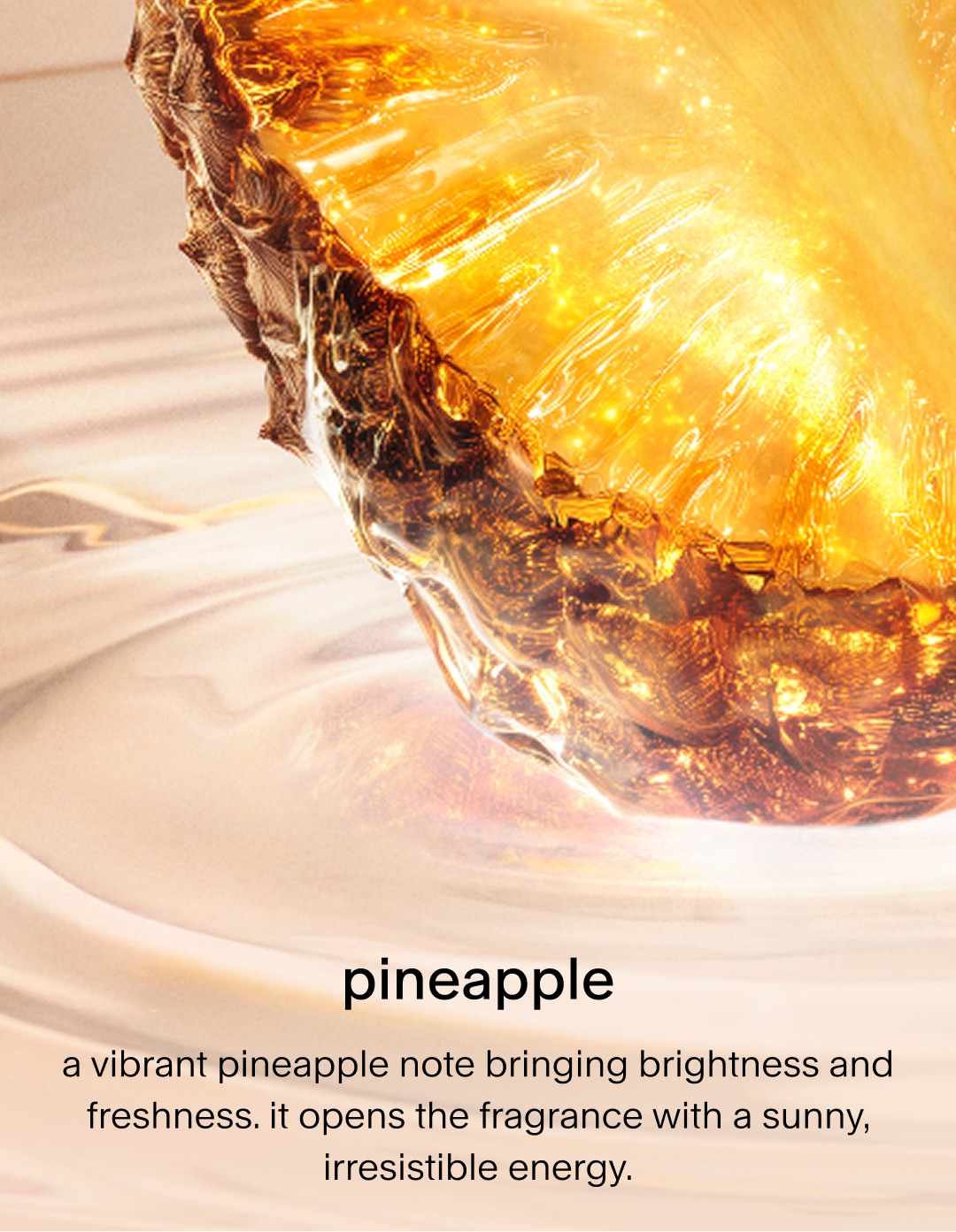 A close-up of a vibrant, glowing golden pineapple slice partially submerged in a creamy liquid. The text describes it as a bright, fresh note that opens the fragrance with sunny, irresistible energy.