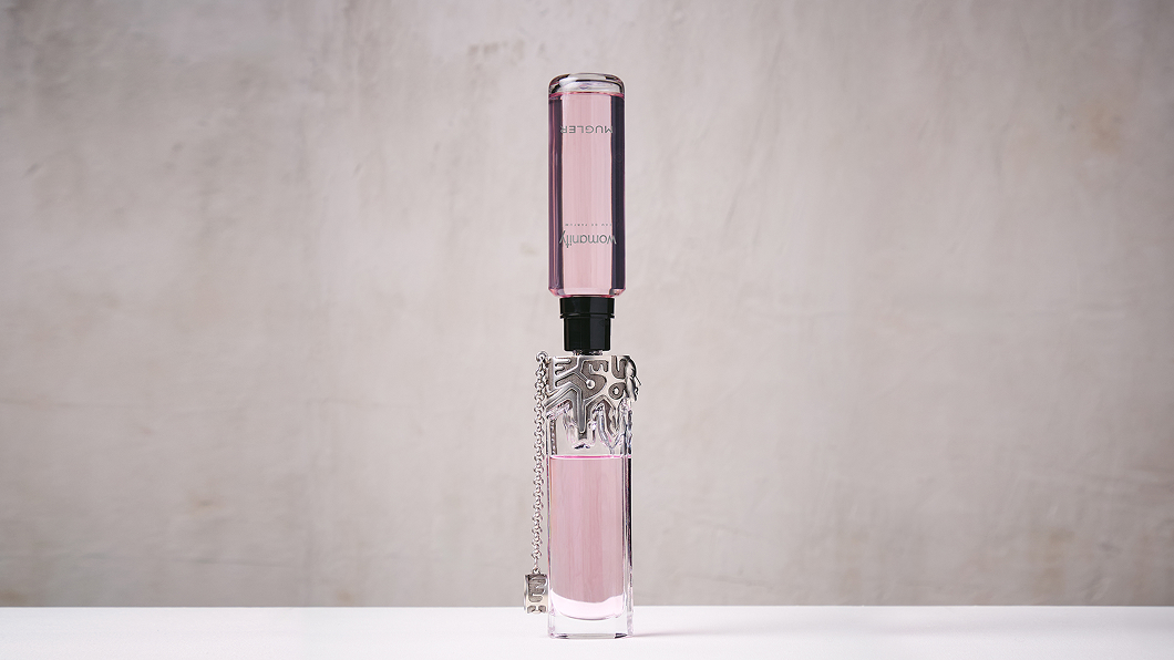 Pink Mugler Womanity refill bottle connected upside down to perfume bottle.