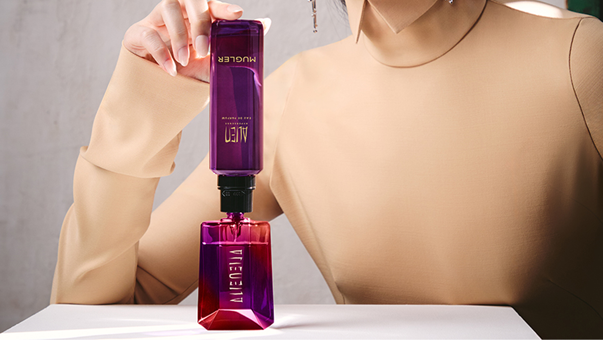 Model refilling Alien bottle from matching purple refill bottle