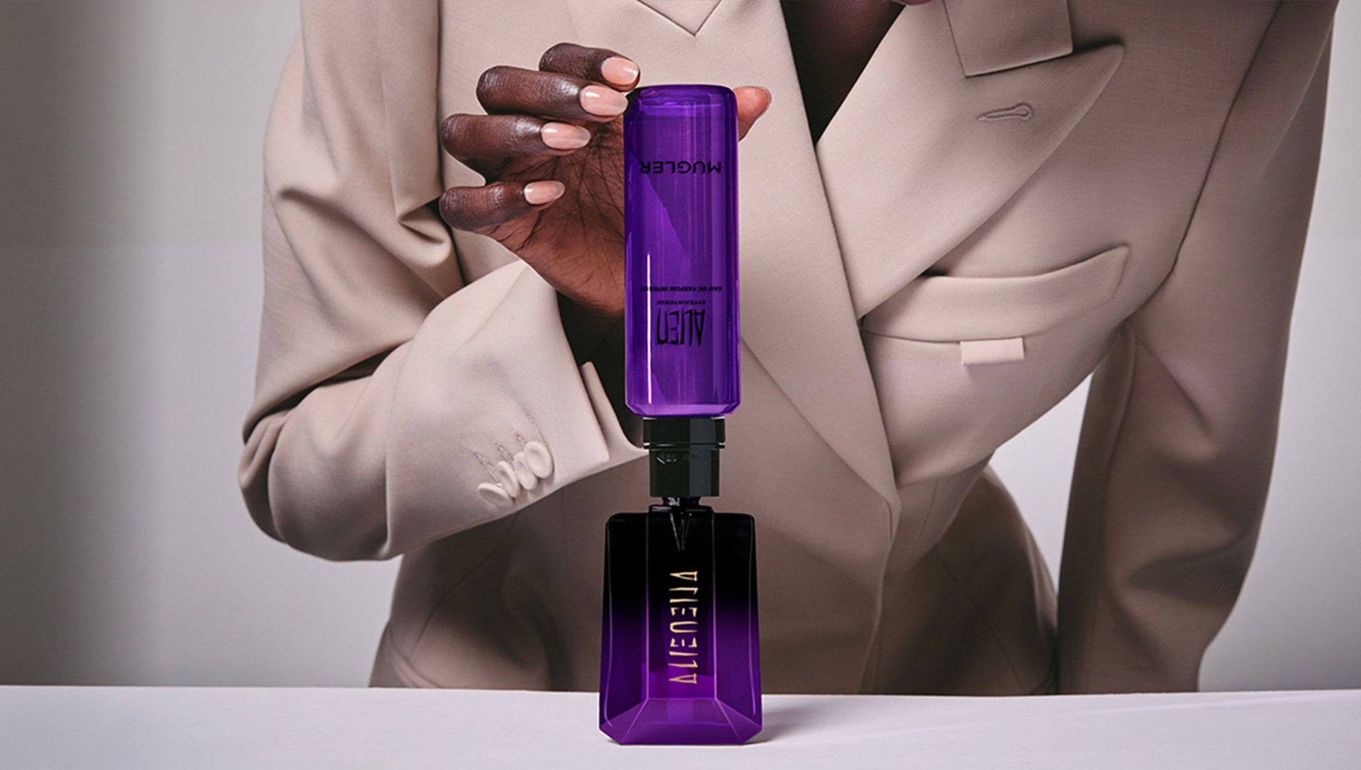 Woman refilling Mugler Angel Stellar star-shaped bottle with refill spray, showcasing eco-responsible refillable fragrance system
